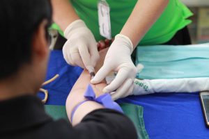 Nurse taking blood from the body.