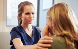 Nurse Treating Teenage Girl Suffering With Depression